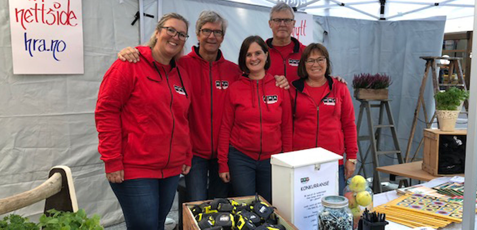 Fem HRA-ansatte står i røde jakker i teltet på Ringeriksdagen 2018.